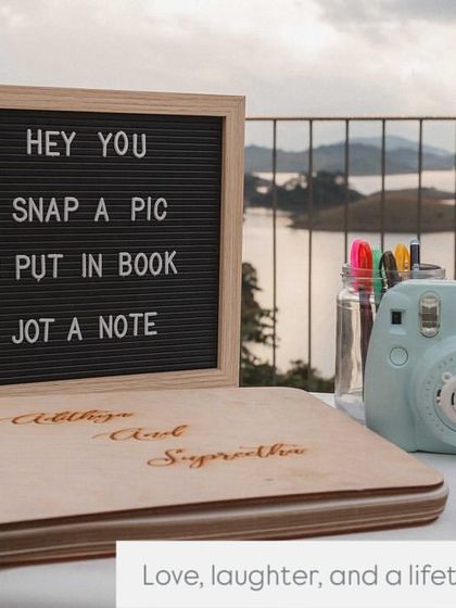 A personalized guest book station at a destination wedding in Wayanad. We set up a polaroid camera and a custom album, inviting guests to "snap a pic, put in book, and jot a note" to create a memory book for the couple.