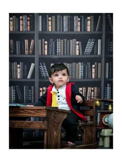 This baby wizard stands at his desk in the library, looking curious. The backdrop of bookshelves and the vintage telephone prop create a rich, scholarly atmosphere for this Harry Potter theme.