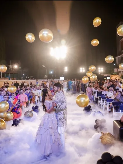 A fairytale first dance on a cloud of smoke, surrounded by floating golden balloons. We turned their Sangeet dance floor into a dreamscape.