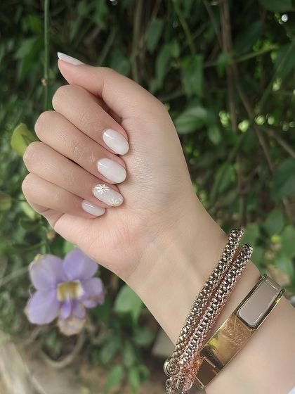 The milky white and daisy nail set looking beautiful in natural outdoor lighting.