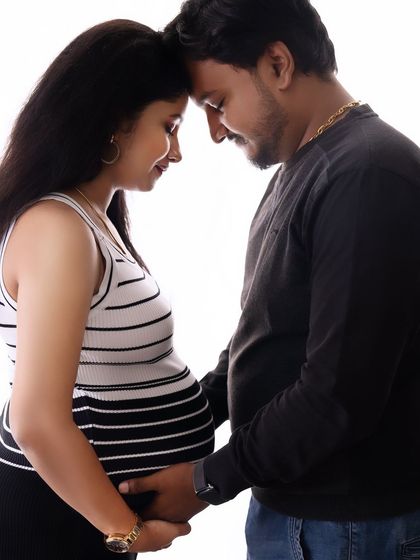 An intimate close-up against a bright white background. This photo highlights the couple's connection and the anticipation of their new arrival.