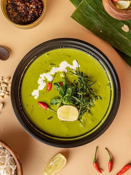 This top-down shot of a Thai green curry is rich with detail. We styled it with raw ingredients like chili, lime, and banana leaves to tell a story about the dish's authentic flavors.