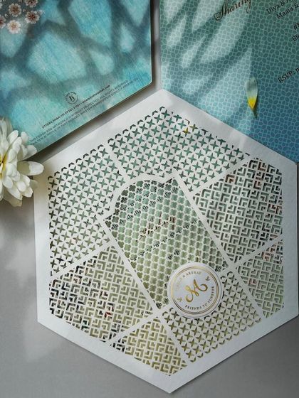 A hexagonal laser-cut invitation with a custom monogram, blending modern geometry with traditional patterns.