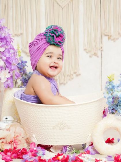 A vibrant flower bath session with a purple theme. The matching turban and colorful petals make for a lively and fun portrait.
