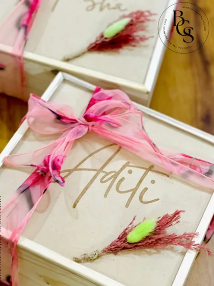 The exterior of my personalized bridesmaid proposal box. The wooden lid is engraved with each bridesmaid's name and adorned with a beautiful printed fabric ribbon and a dried floral accent.