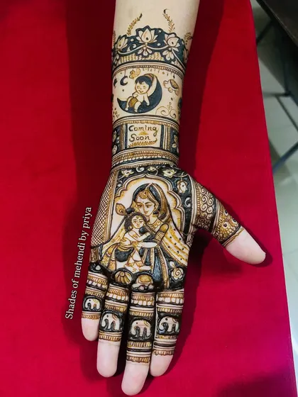 Celebrating the journey to motherhood with a custom baby shower mehendi. This design features a loving portrait of a mother and child, with a "Coming Soon" message and cute baby elephants on the fingers. It's a beautiful way to capture this precious time.