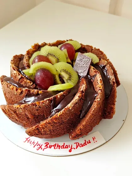 This is a perfect example of my wholesome baking, a whole wheat Bundt cake made for a birthday. It's topped with a rich chocolate ganache, fresh kiwi, and grapes, proving that healthy can be celebratory and delicious.