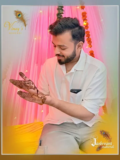 The groom inspecting the fine details of his custom henna art.