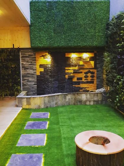 A stunning water feature with a stacked stone design, illuminated from within to highlight the texture of the stone and the flowing water.