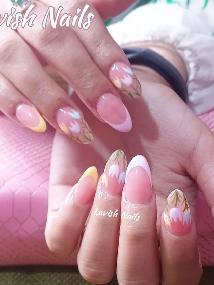 A beautiful spring-themed set with pastel-colored French tips and hand-painted tulips on a natural base.