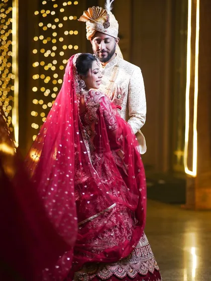 A romantic portrait of the couple, with the bride's red veil adding a beautiful flow and color to the image.