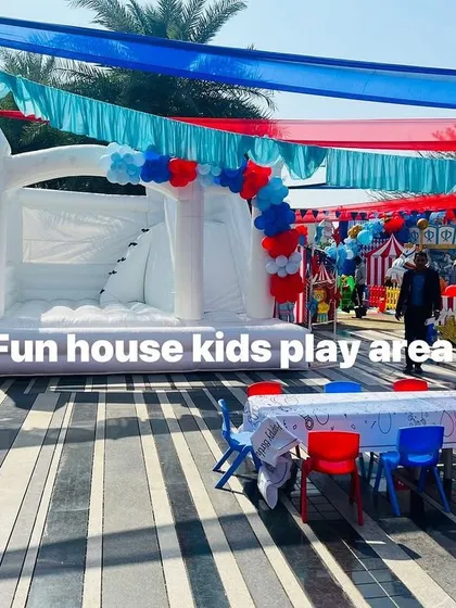 An outdoor carnival party where our colorful tables and chairs are paired with a large white bouncy castle. The red and blue furniture ties in perfectly with the theme's color scheme.