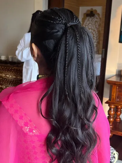 A fun and youthful ponytail with multiple thin braids scattered throughout. This adds texture and interest to a simple high ponytail and is perfect for a Mehendi or a young bridesmaid.