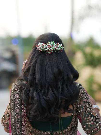 A view of the beautiful floral hair accessory in Dr. Saruna's reception hairstyle. The colourful beads add a unique and festive touch to her look.