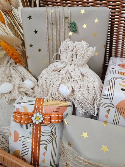More details from the boho-themed trunk. The macrame potlis with shell details and the patterned paper with a daisy-adorned ribbon create a relaxed and stylish vibe.