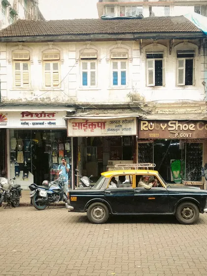 A Kaali-Peeli taxi parked on a cobblestone street in an old neighborhood. This shot is rich with nostalgic charm, capturing the timeless character of both the vehicle and the city's architecture.