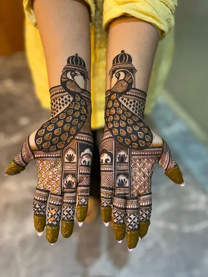 A bold and beautiful design centered around the majestic peacock. The feathers flow down the palm, creating a striking visual, while the forearms feature traditional elephant and architectural elements.