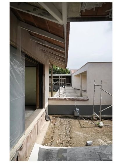 A view from within the Alibaug house during construction, looking out into a side courtyard. The design creates multiple connections between the interior and the surrounding landscape.