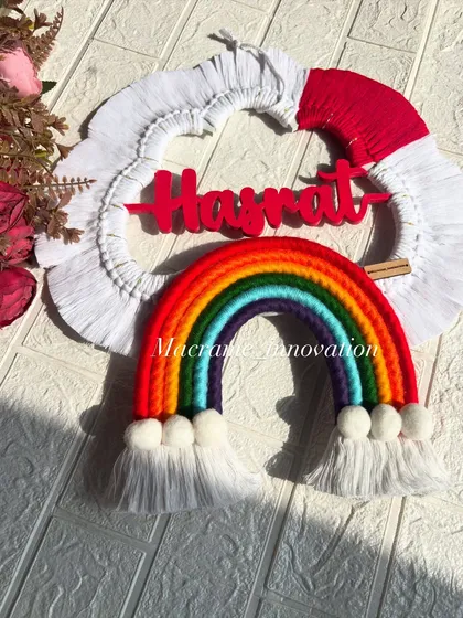 A full view of the custom name hanging for Hasrat. The classic rainbow colors against the white cloud frame make this a cheerful and timeless piece for any kid's room.