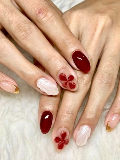 Red nails will always have an agenda. This set combines glossy wine-red nails with 3D red flowers, white shell-textured accents, and gold tips for a festive and glamorous vibe.