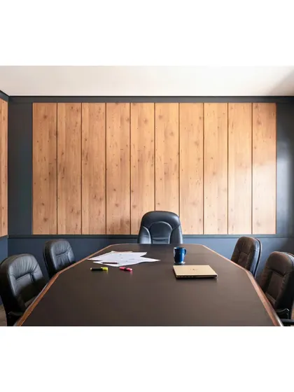 This is the conference room in the Project Rooftop office, designed with a minimal and balanced color palette. Muted veneered panels line the main wall, framed by a bluish-gray paint that continues around the window, creating a striking and sophisticated look for meetings.
