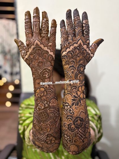 This full bridal design features a classic combination of paisleys on the palms and intricate floral patterns covering the arms.
