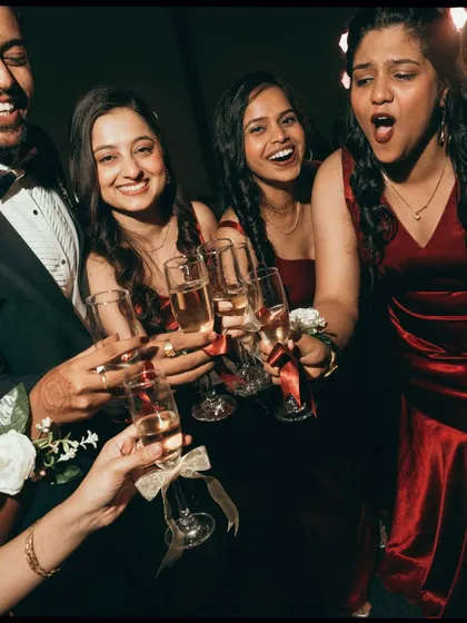 A toast to the happy couple. This shot of the bridesmaids raising their champagne glasses is full of laughter and celebration, capturing the joy of the wedding party.