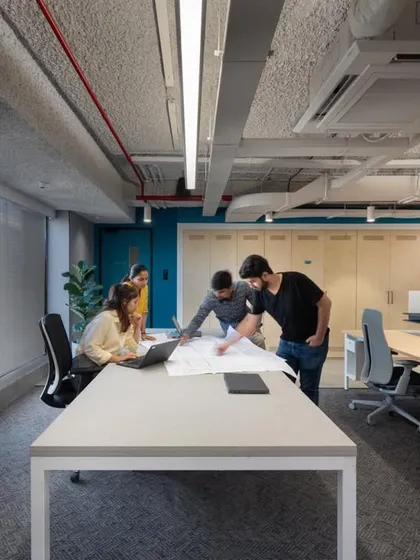 A collaborative work session in progress. Our office designs include large, open tables where teams can gather to review plans and brainstorm ideas together.