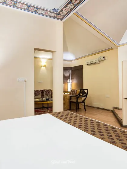 The spacious presidential suite at Vijayshree Resort, featuring traditional painted borders on the ceiling. The room is a blend of modern comfort and heritage-inspired design details.
