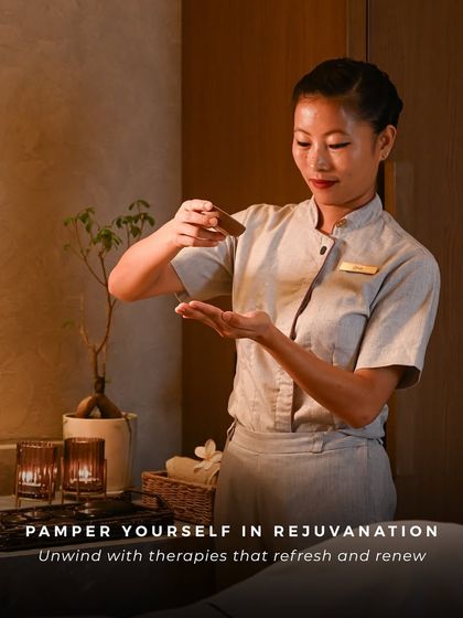 A therapist prepares a custom blend of oils for a massage. The warm lighting and serene focus highlight the personalized attention and expertise that defines every therapy at Ksema Spa.