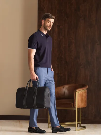 A shot for Moral Code footwear, identical to 147, highlighting a duffel bag and loafers. The complete look is polished and perfect for travel or a weekend getaway.