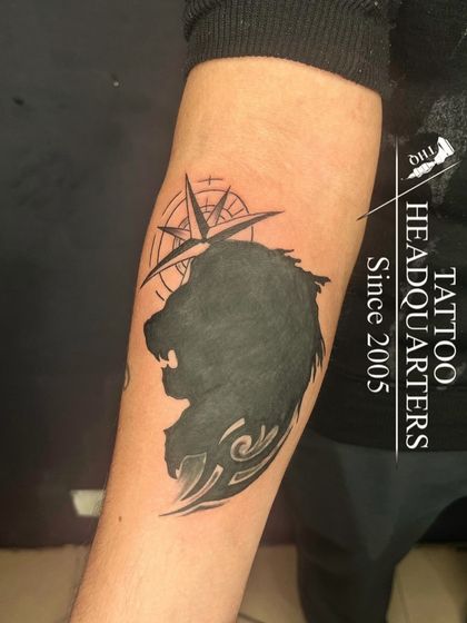 A silhouette of a lion's head against a compass, representing guidance, strength, and leadership.