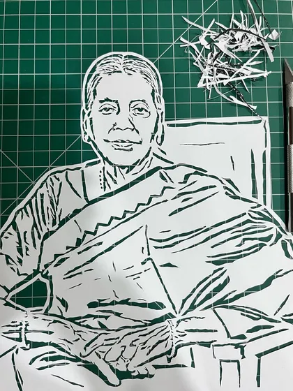 This is a look at a portrait for singer Hariharan's mother, Smt. Alamelu, right after the cutting was done. You can see my craft knife and the tiny paper pieces left behind from the detailed, manual work.