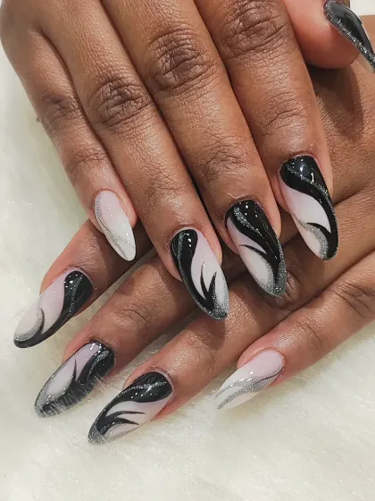 A full view of the black and silver swirl nails, showing how the design flows across each nail to create a cohesive, artistic manicure.