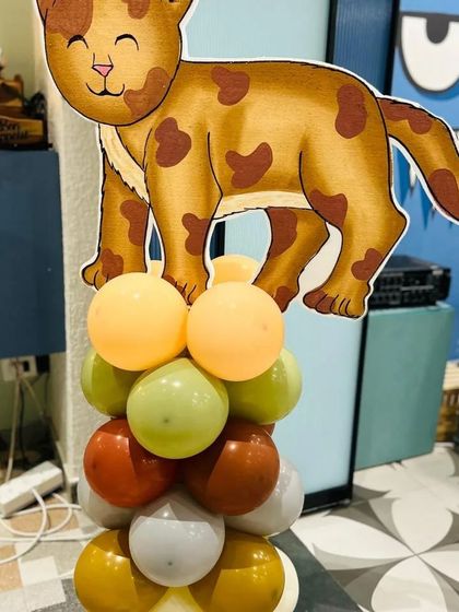 A spotted cat cutout on a balloon column, adding to the variety of feline friends at the party.