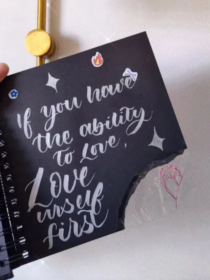 A reminder to myself and everyone else, done in white calligraphy on black paper: "If you have the ability to love, love yourself first."