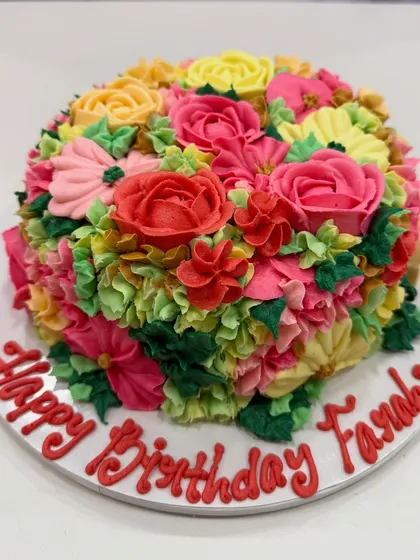A full view of the vibrant floral buttercream cake made for Farah Khan's birthday celebration.