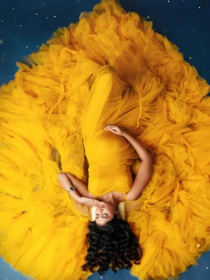 Lie back and glow. This overhead shot in our sunny yellow tulle gown creates a radiant, flower-like effect for a joyful and artistic maternity photo.