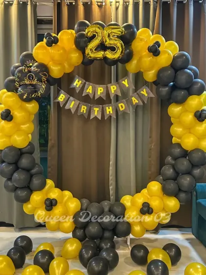 A black and yellow balloon ring for a 25th birthday, with a "Happy Birthday" banner inside.