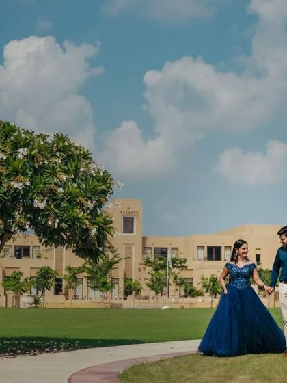 A candid shot of a couple walking hand-in-hand, showing how this navy blue gown moves beautifully for dynamic photoshoot moments.