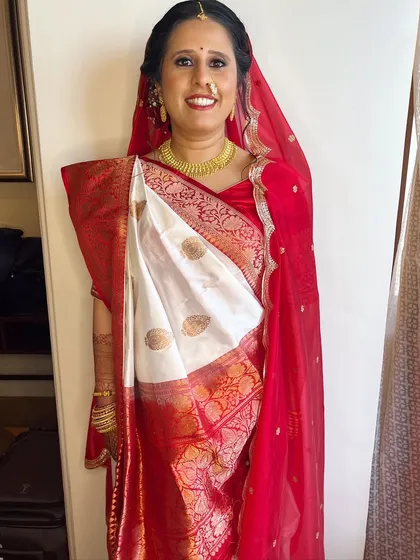 The full bridal look for my Gujarati bride. The red dupatta beautifully frames her face, and the makeup highlights her happy smile.