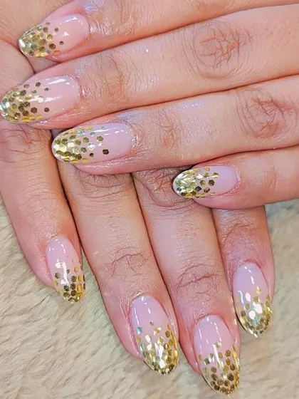 A celebration on your fingertips. This glamorous design features a cascade of gold glitter sequins from the tip down, creating a festive and eye-catching ombre effect.