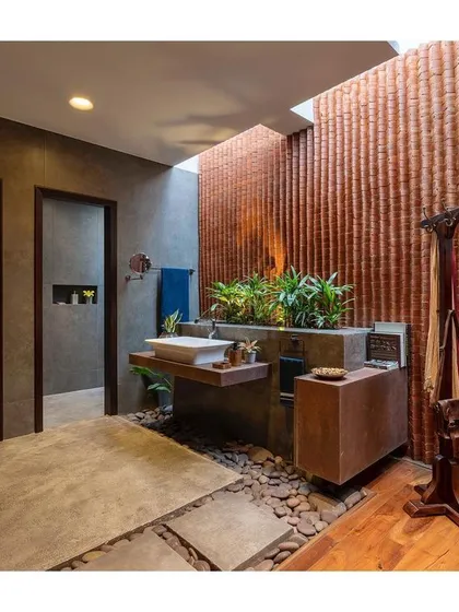 This bathroom from the "Between Two Trees" project redefines personal space. By incorporating an open-to-sky court with a textured brick wall and plants, we've created a spa-like sanctuary that feels connected to nature.