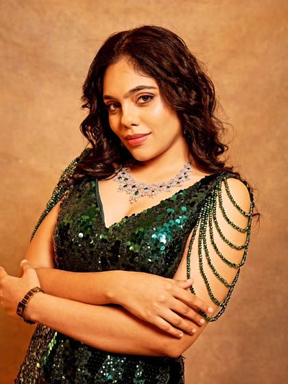 A close-up of Nayana in the emerald green gown, showcasing the intricate sequin work and how beautifully it complements her features.