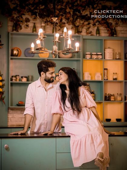 A romantic look shared between a couple in a charming, retro-style kitchen set, perfect for a lifestyle pre-wedding shoot.