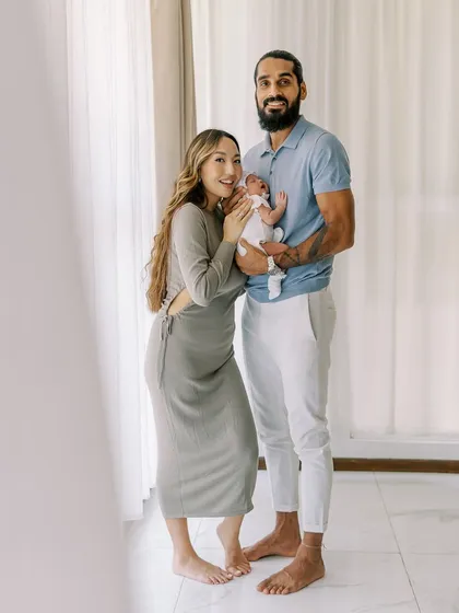 A full-length portrait of a new family. This shot shows the context of their home, making the memory even more personal and meaningful.