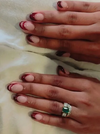 A bold and elegant choice for a winter wedding or party. This is a deep maroon French tip on rounded nails, which looks very sophisticated.