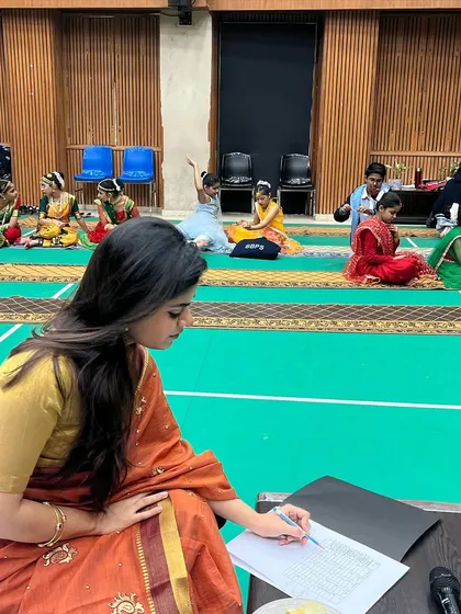 Taking detailed notes during the "Hunarbaaz" solo classical dance competition at Bal Bharti Public School. Every participant deserves careful attention, and my feedback is tailored to help them refine their art.