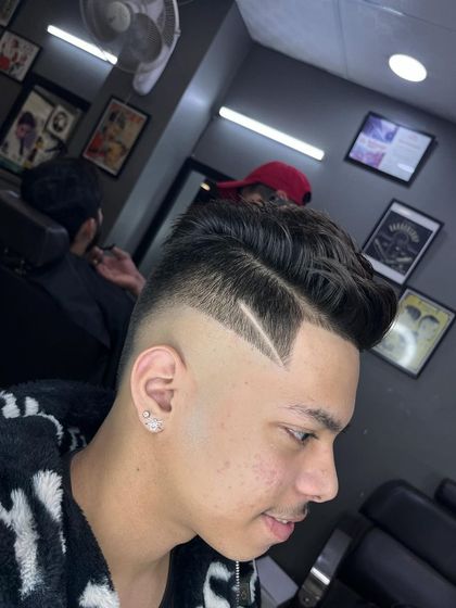 A clean high fade featuring a sharp, angular line design. This style combines a classic cut with a modern artistic element.