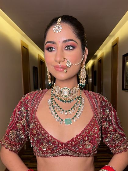 A beautiful portrait of the bride. Her makeup features a soft pink eyeshadow and a natural lip color, perfectly balancing her heavy jewelry and colorful outfit.